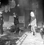 831220 Afbeelding van enkele brandweermannen bij het blussen van een brand in de speelzaal van de kleuterschool Het ...